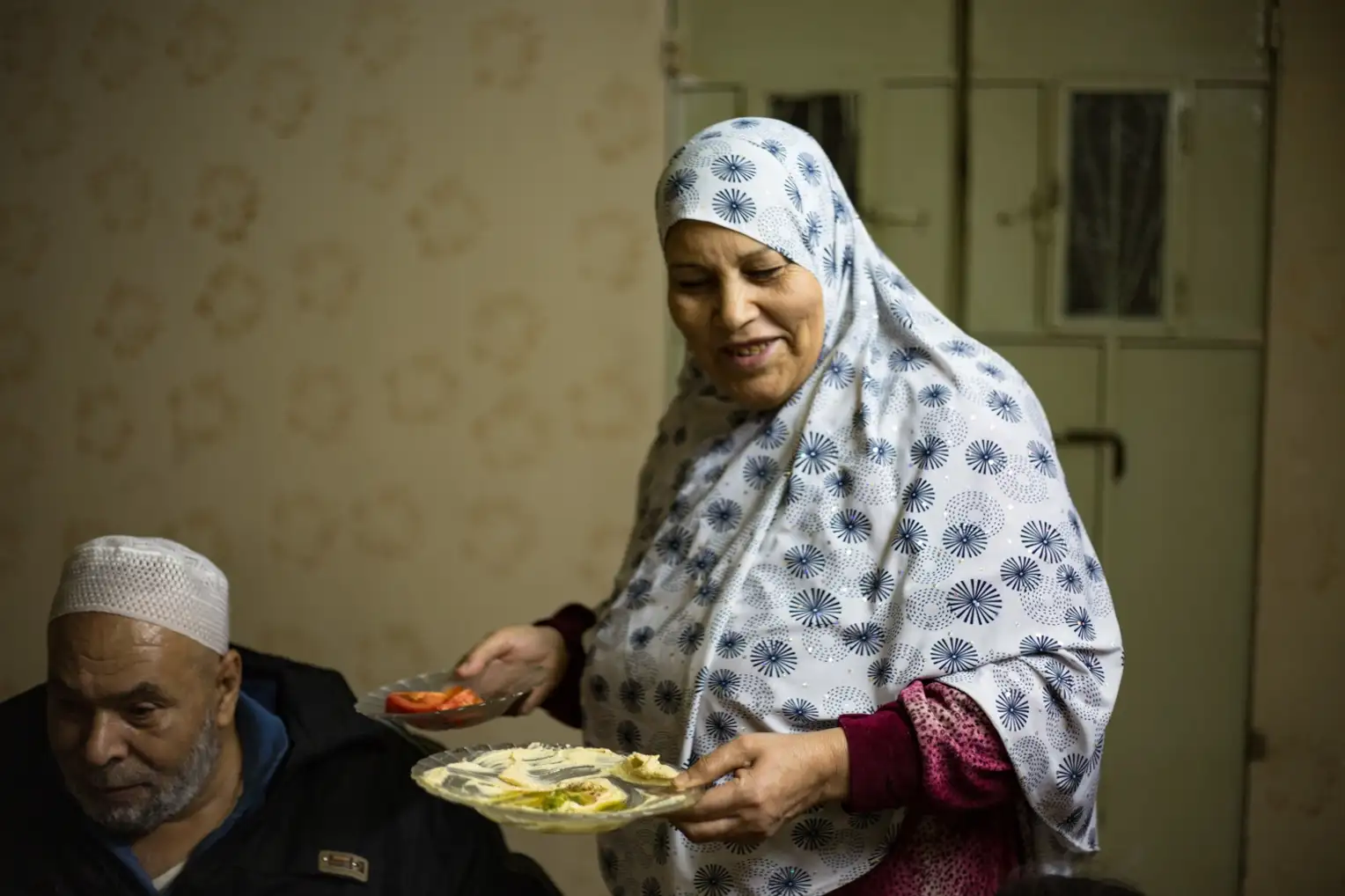 A grandmother clears the table after a family meal